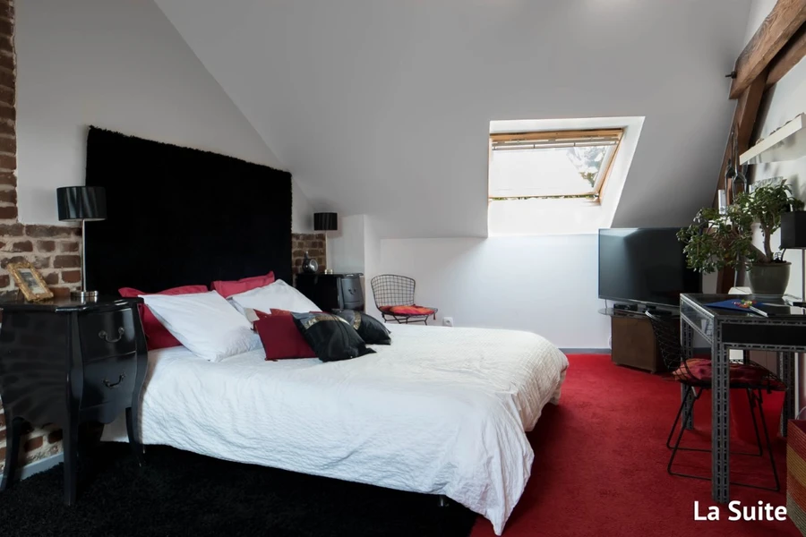 Espace nuit de La Suite avec tête de lit noire et velux, Clos de Royaucourt