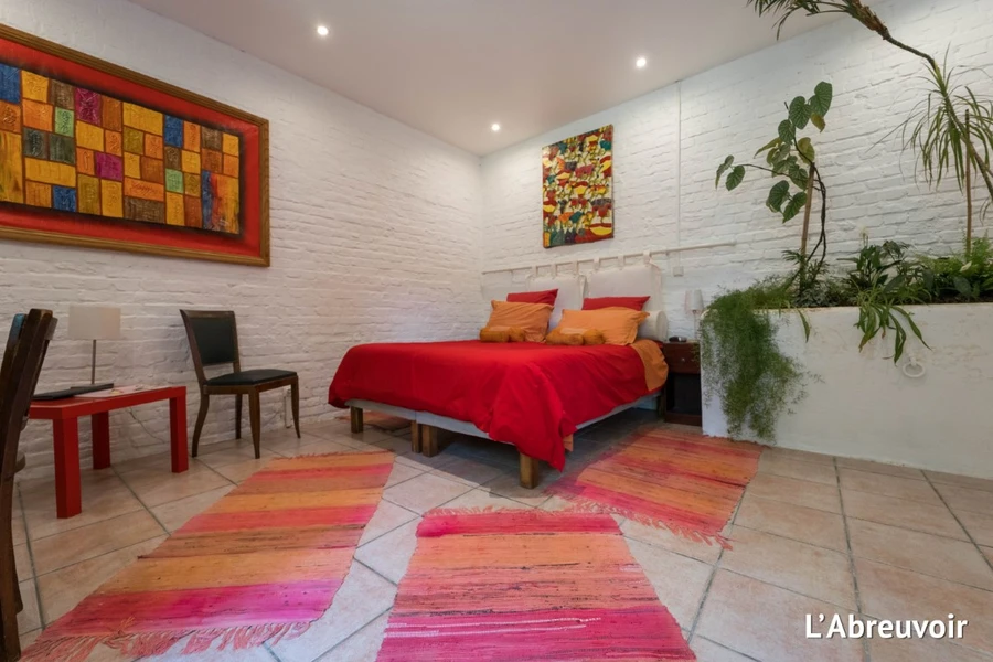 Chambre L'Abreuvoir du Clos de Royaucourt, lit rouge et mur en briques blanchies