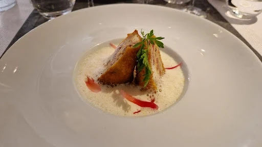 Entrée raffinée servie au Clos de Royaucourt : feuilleté doré et velouté crémeux dressés en assiette blanche