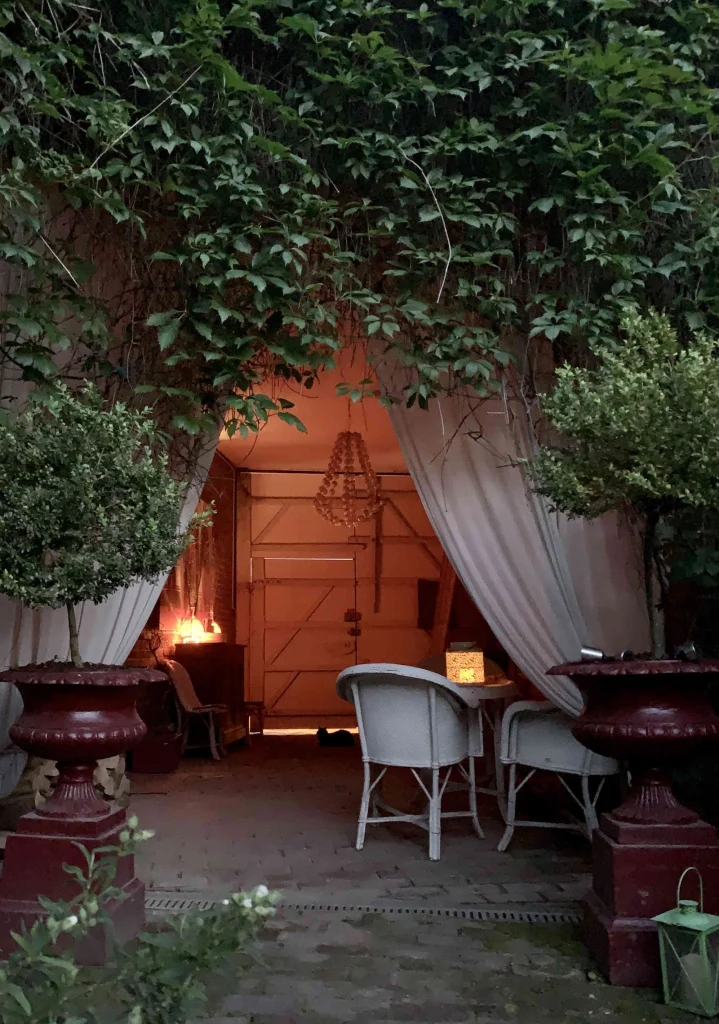 Le porche du jardin à la tombée de la nuit, éclairé par des lanternes