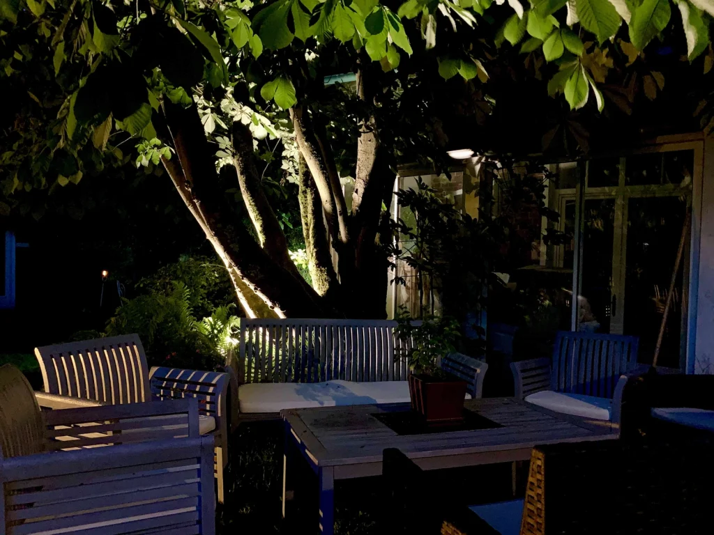 Salon de jardin éclairé sous le marronnier, en soirée